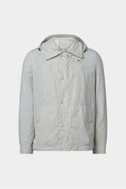 Vue sur fond blanc d'un blouson beige clair en 100% polyamide, fermeture à zip et boutonnée et poches latérales.