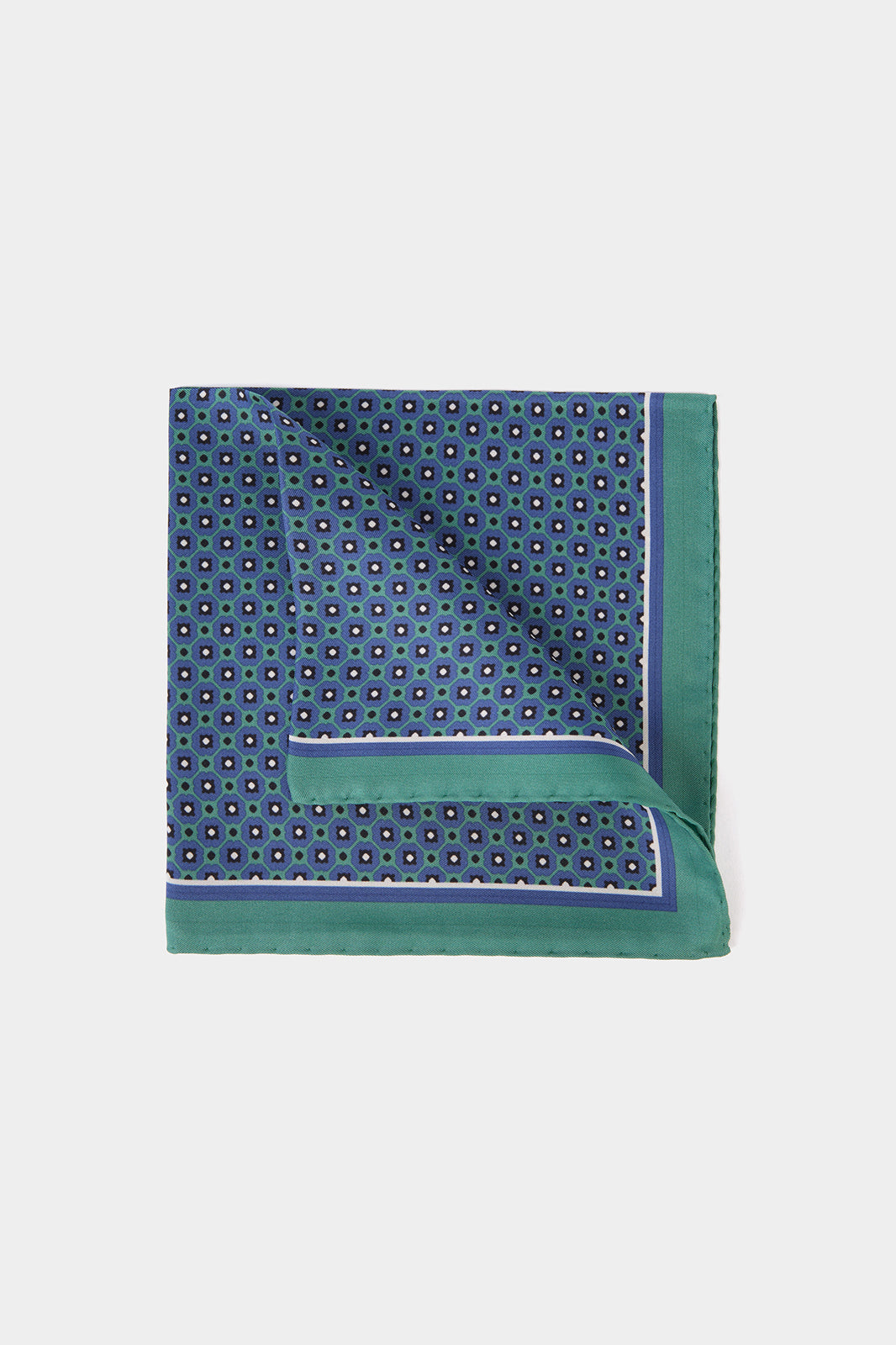 Vue sur fond blanc d'une pochette en 100% soie à fond vert et à motif géométrique bleu