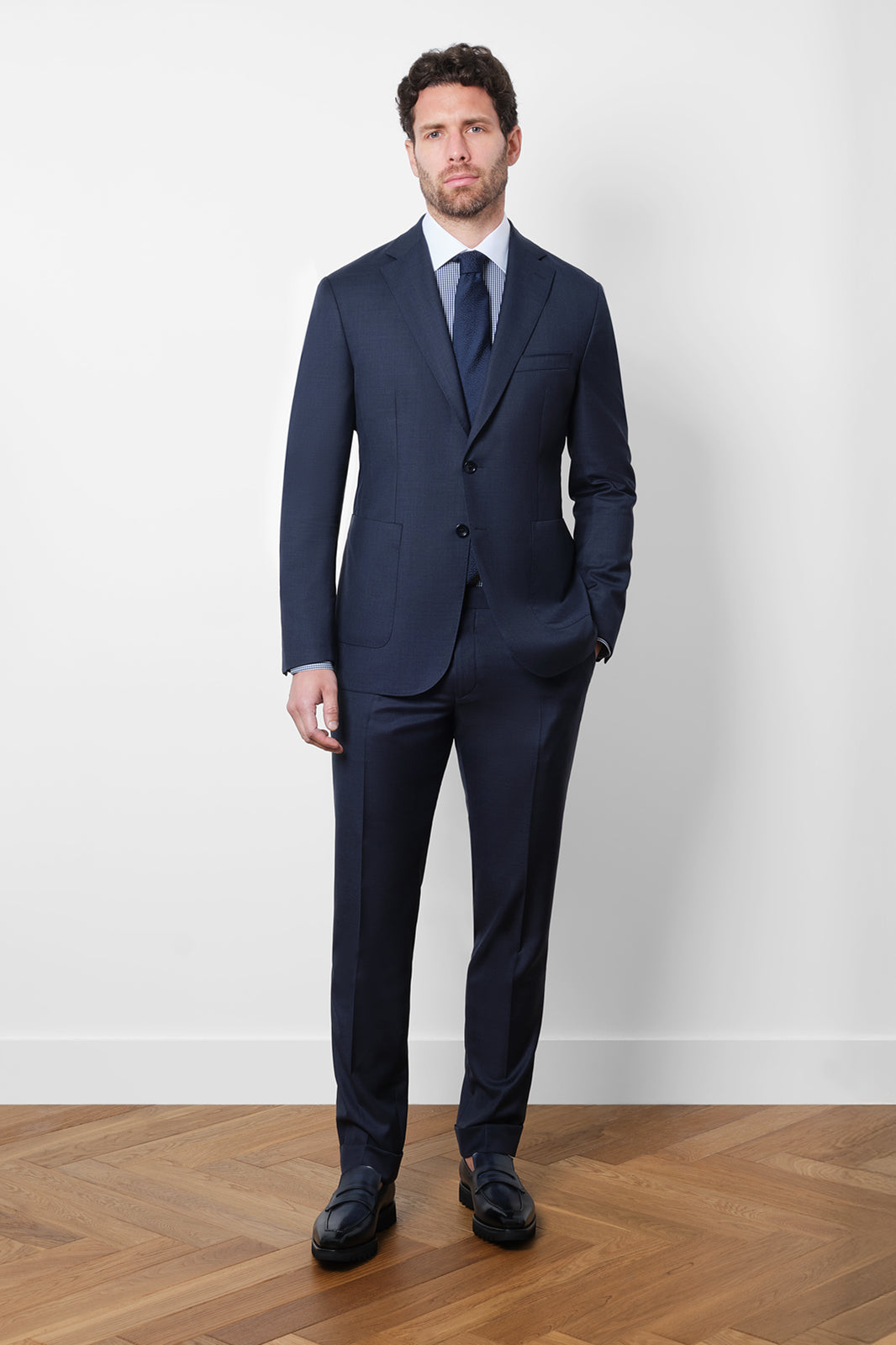 Découvrez notre costume coupé cintrée en 100% laine, composé d'une veste à 2 boutons sans épaulette et non doublée avec les poches plaquées sur le devant, et d'un pantalon à coupe traditionnelle.