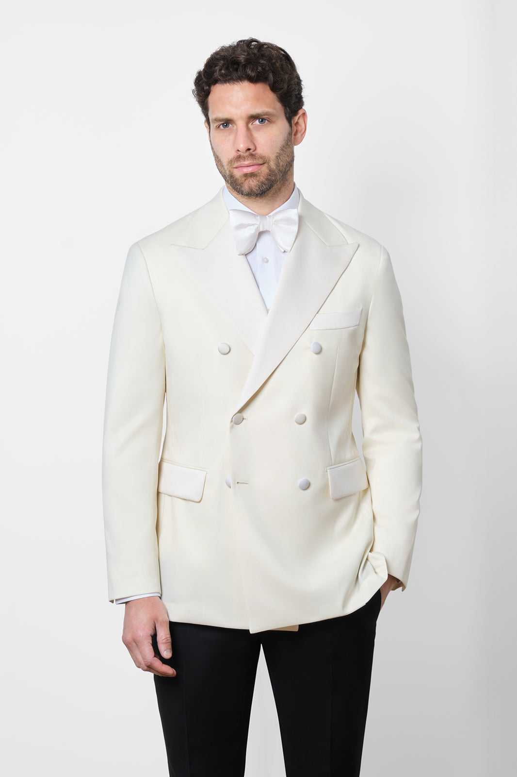 Vue sur fond blanc d'un smoking ou tuxedo veste blanche et pantalon noir à patte de serrage et noeud papillon en soie
