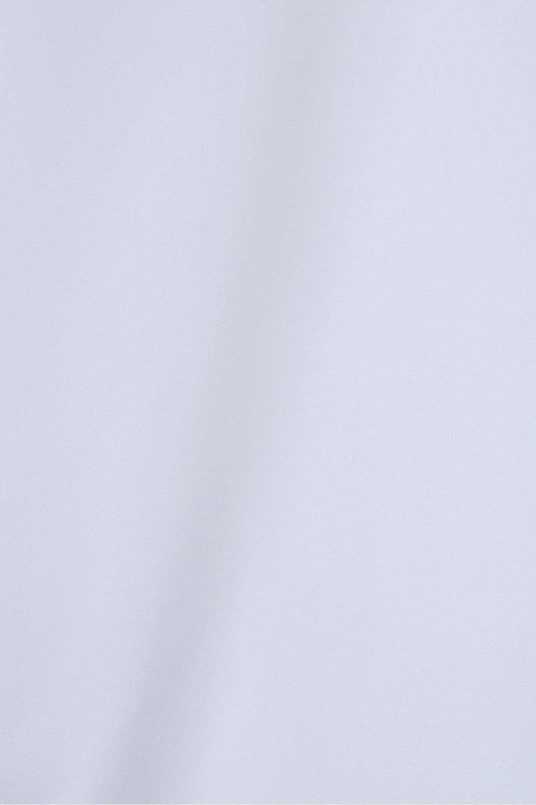 Zoom sur le tissu de la chemise blanche en coton.