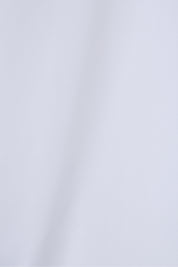 Zoom sur le tissu de la chemise blanche en coton.