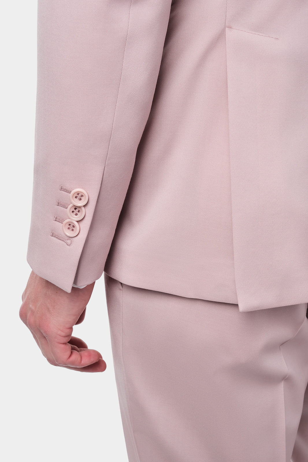 Vue rapproché de la manche de la veste de costume rose poudré.