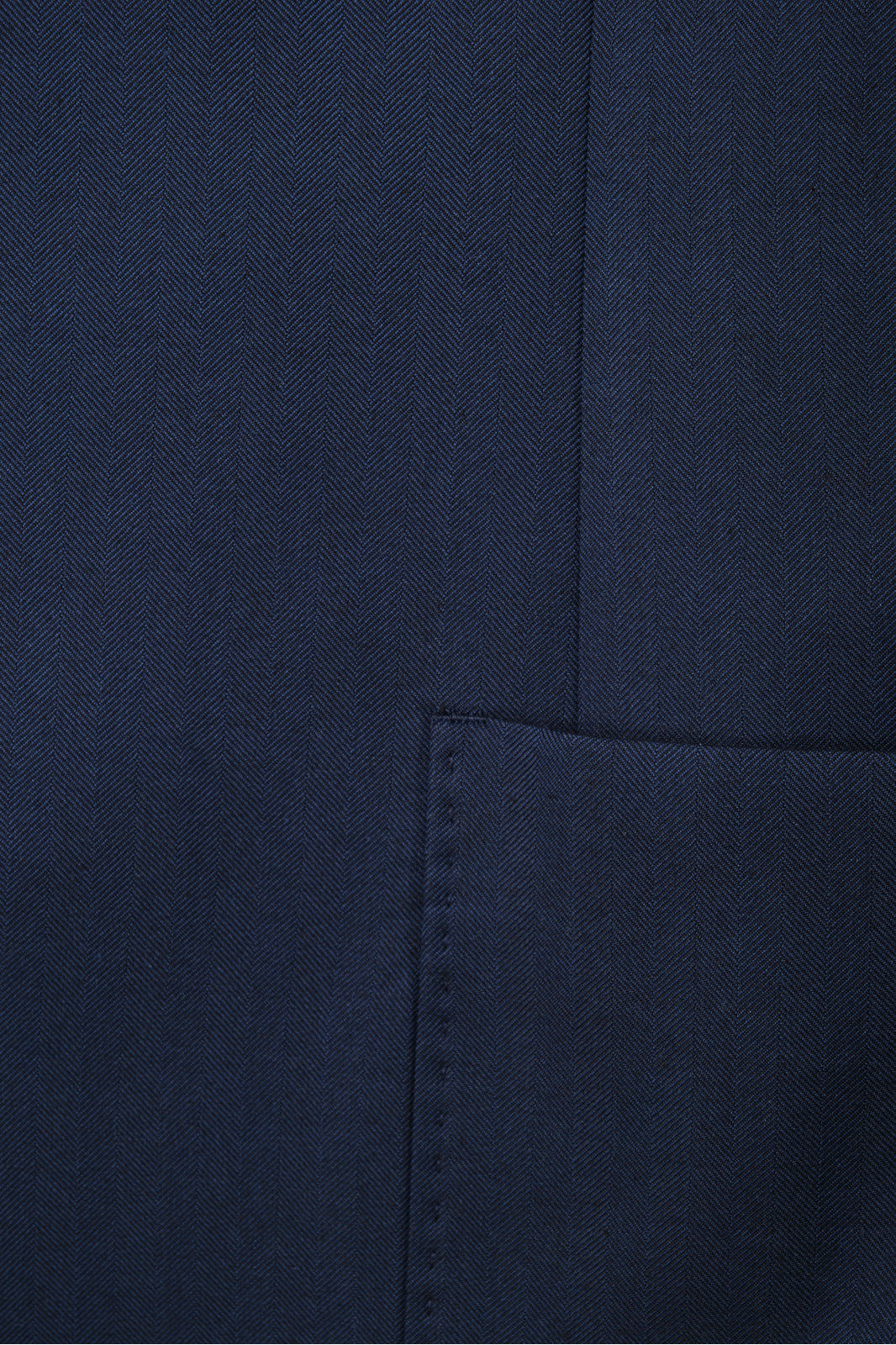 Détails  de la veste de costume bleu marine cintrée.