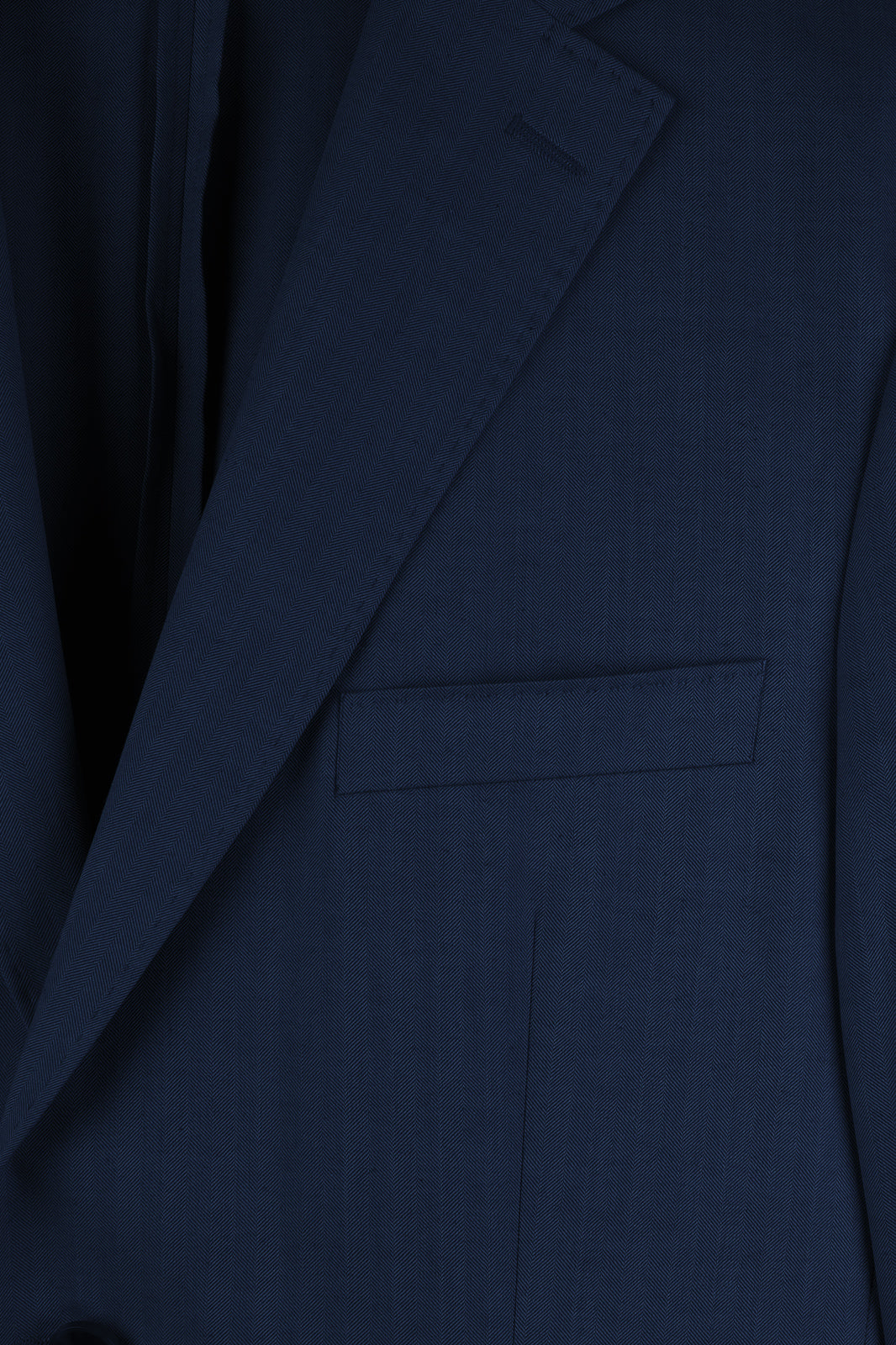 Détails  de la veste de costume bleu marine cintrée.