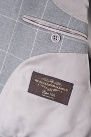 Zoom sur l’étiquette et la poche intérieure de la veste du costume gris à carreaux.