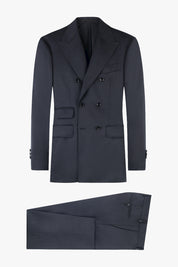 Un costume gris anthracite avec une veste croisée à 6 boutons et un pantalon traditionnel assorti. La veste possède de larges revers en pointe et plusieurs poches à rabat sur le devant.