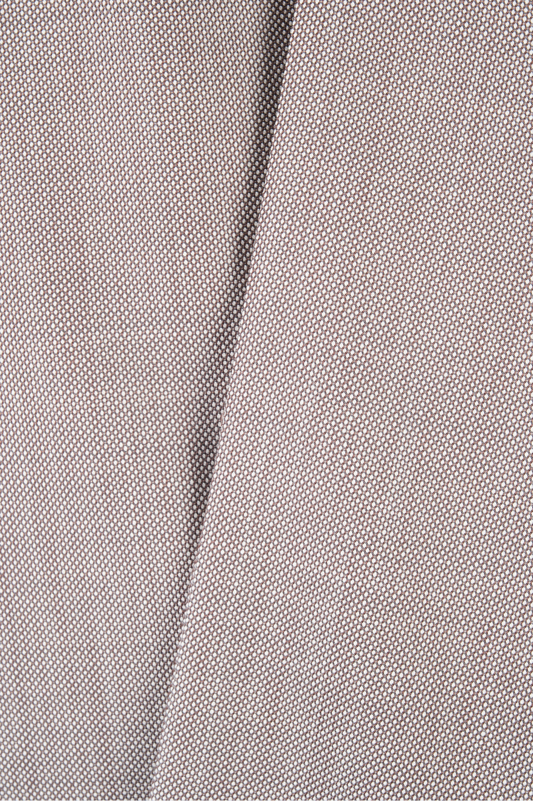 Plan rapproché sur le pantalon de costume en tissu grain de caviar beige.