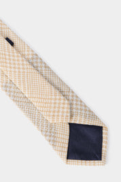 Cravate à  motif rayures croisées beige et blanche, vue arrière et à plat.