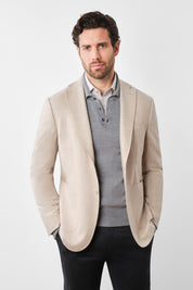 Vue sur fond blanc d'une veste beige en laine et cachemire de chez E.Thomas en coupe droite cintrée et 2 boutons.