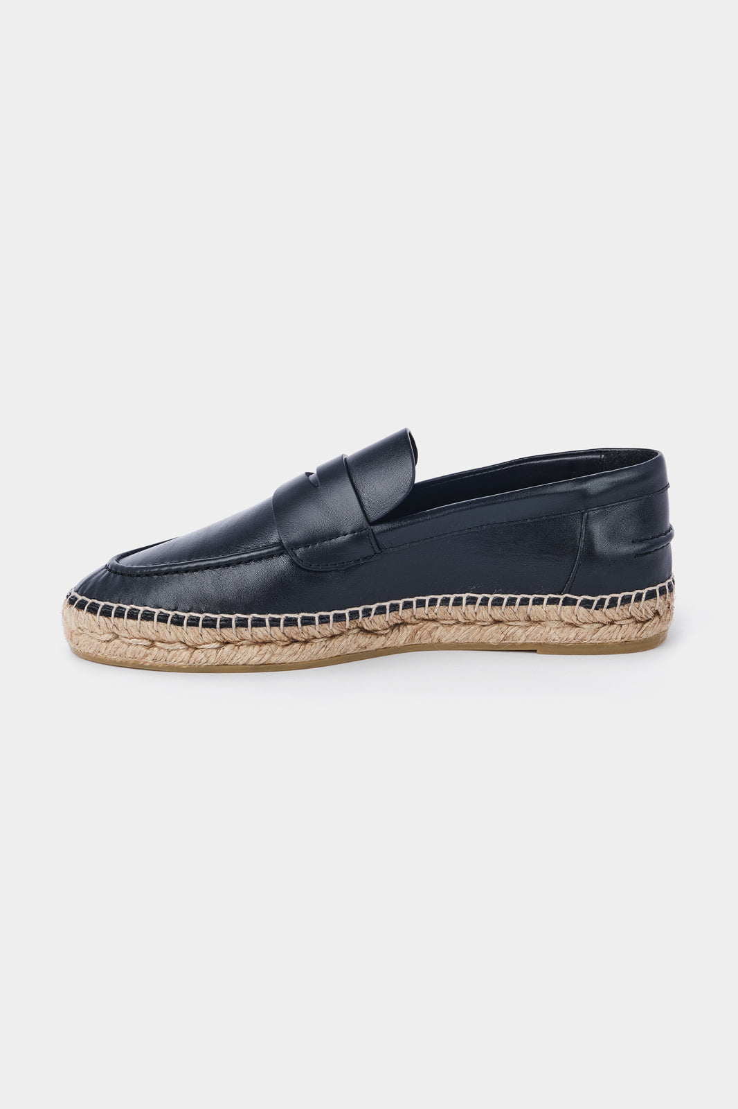 Vue de côté d'une espadrille en cuir noir avec une semelle en corde tressée. Elle a un design de mocassin avec des coutures apparentes sur le dessus.