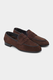 Vue sur fond d'un mocassin type "penny loafer" en peau marron avec les bordures tréssées en cuir