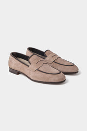 Vue sur fond blanc d'une paire de mocassins en daim en couleur taupe.