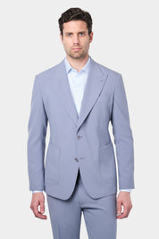 Homme portant un costume lilas à coupe cintrée, composé d'une veste à 2 boutons avec des poches plaquées et des revers en pointe, accompagné d'un pantalon assorti. Il poste également une chemise à rayures bleues et blanches.