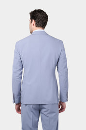 Homme de dos portant un costume lilas à coupe cintrée, composé d'une veste à 2 boutons avec des poches plaquées et des revers en pointe, accompagné d'un pantalon assorti. Il poste également une chemise à rayures bleues et blanches.
