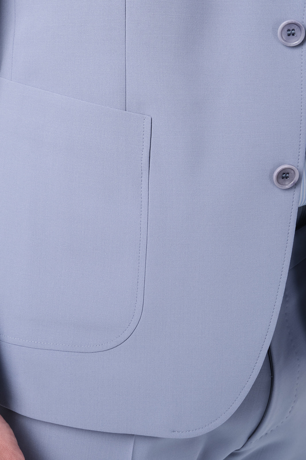 Zoom sur la matière et la poche de la veste du costume lilas.