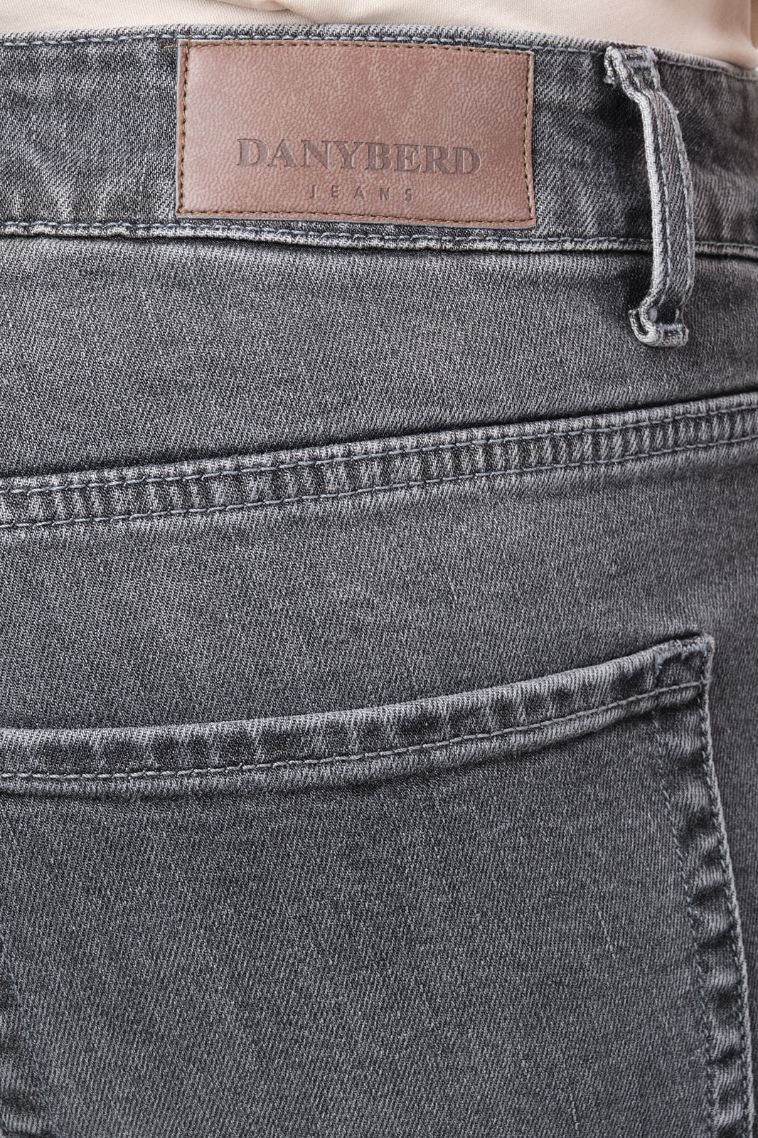 Zoom sur les détails d'un jean coupe slim en coton et élasthanne de couleur grise.