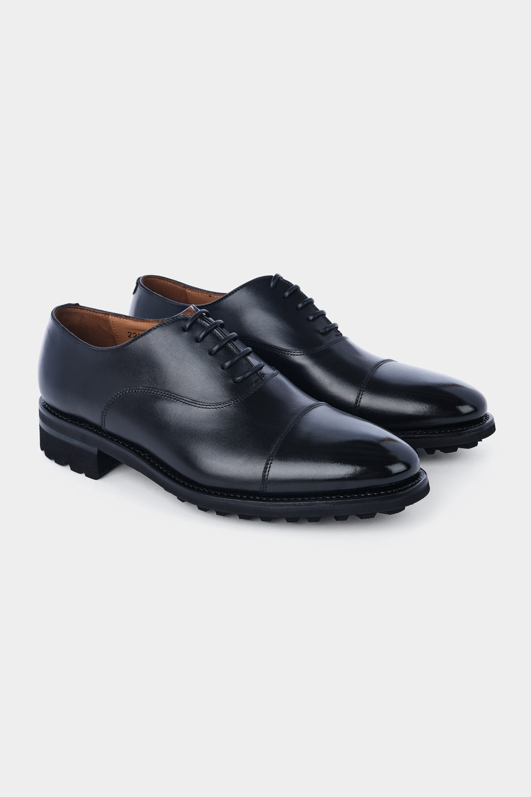 Vue sur fond blanc d'un soulier à lacets en cuir noir avec semelle épaisse et anti-dérapante.