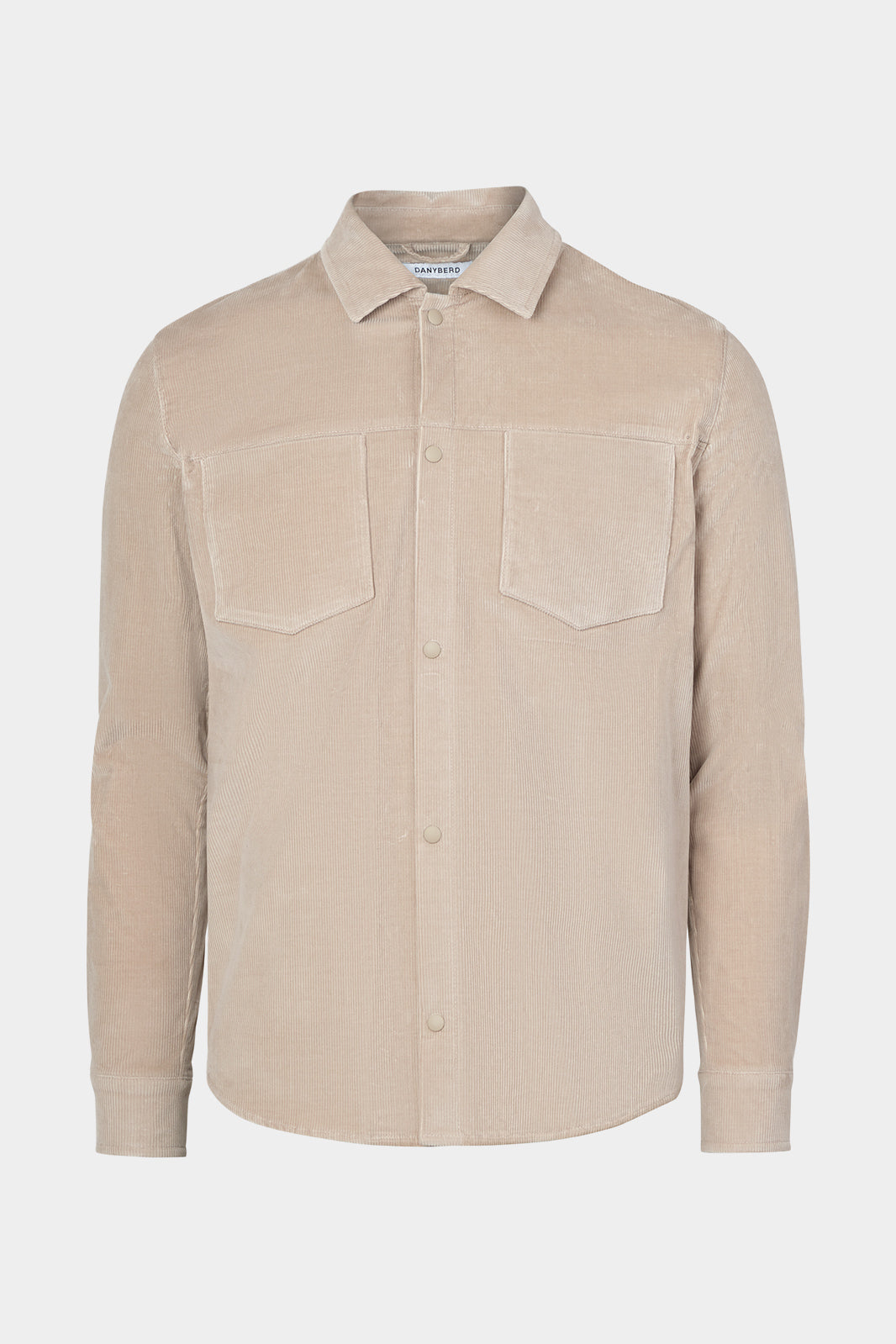Vue sur fond blanc d'une sur-chemise en velours côtelé beige avec poche poitrine et boutonnage pression.