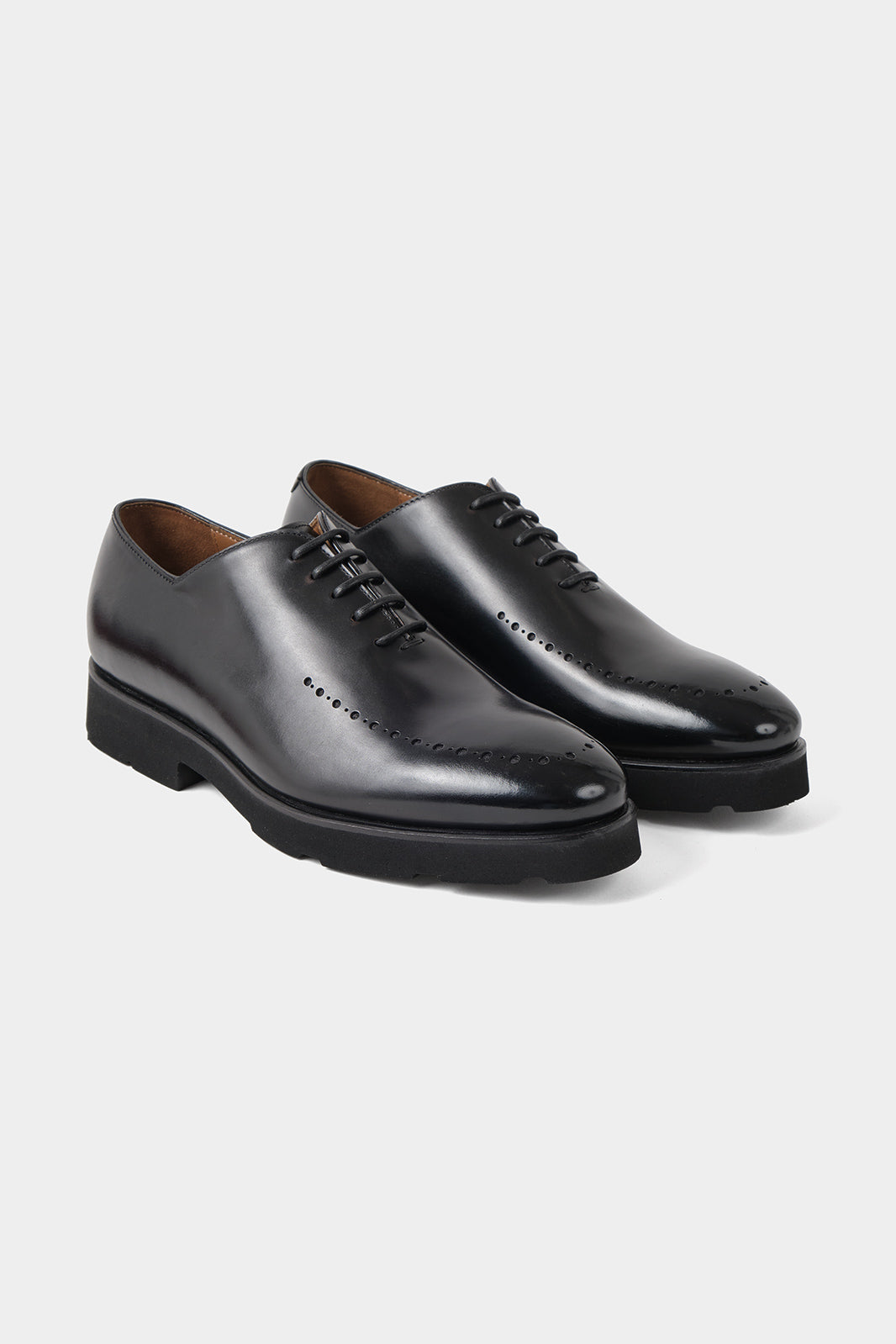 Vue sur fond blanc d'un souliers à lacets patiné avec œillets en noir