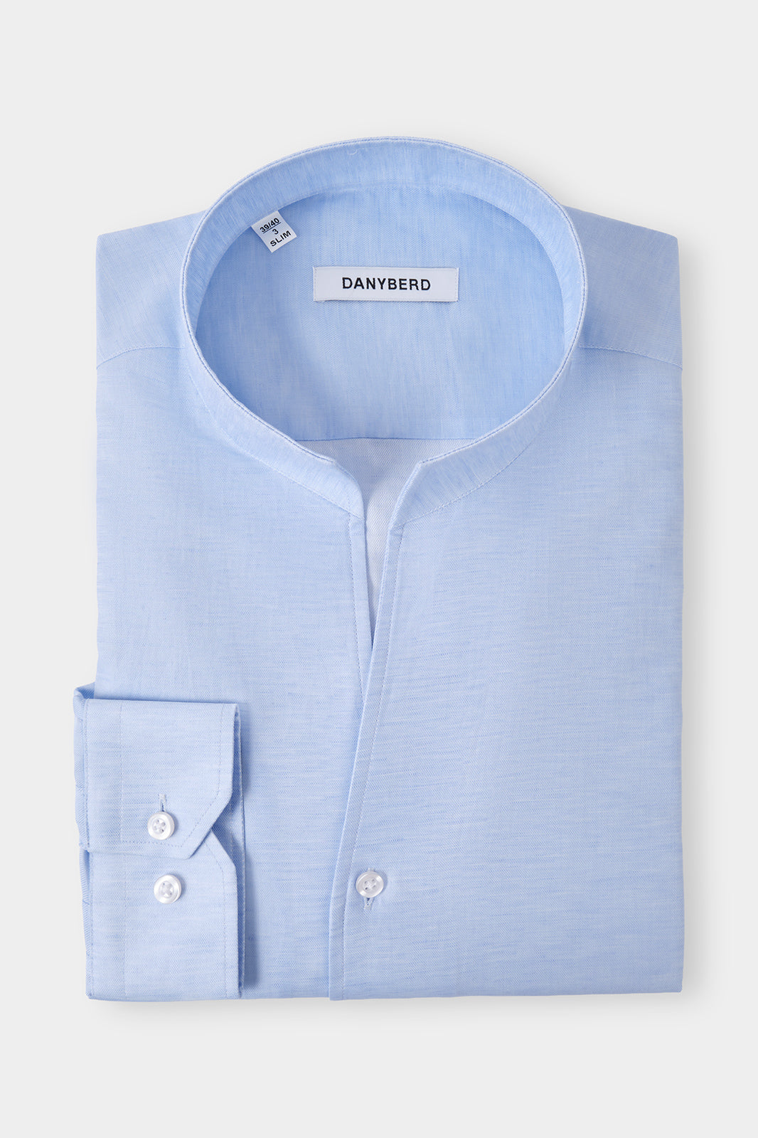 Vue sur fond blanc d'une chemise col indien en coton et lin couleur bleu, sur un tissu en 66% coton et 34% lin de chez Albini.