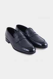 Vue sur fond blanc d'un mocassin en cuir noir souple et lisse avec semelle fine.