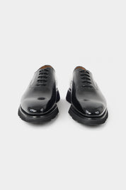 Vue sur fond blanc d'une paire de souliers à lacets en noir en 100% cuir 