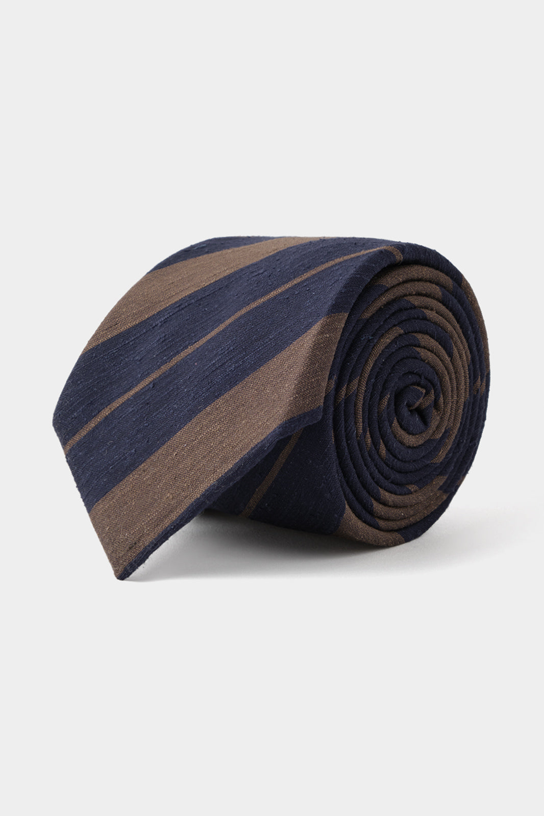 Vue sur fond blanc d'une cravate 100 % soie rayée - Marine et Marron. 
Elle a 7,5 cm de largeur, 150 cm de longueur et est 100% soie effet lin.