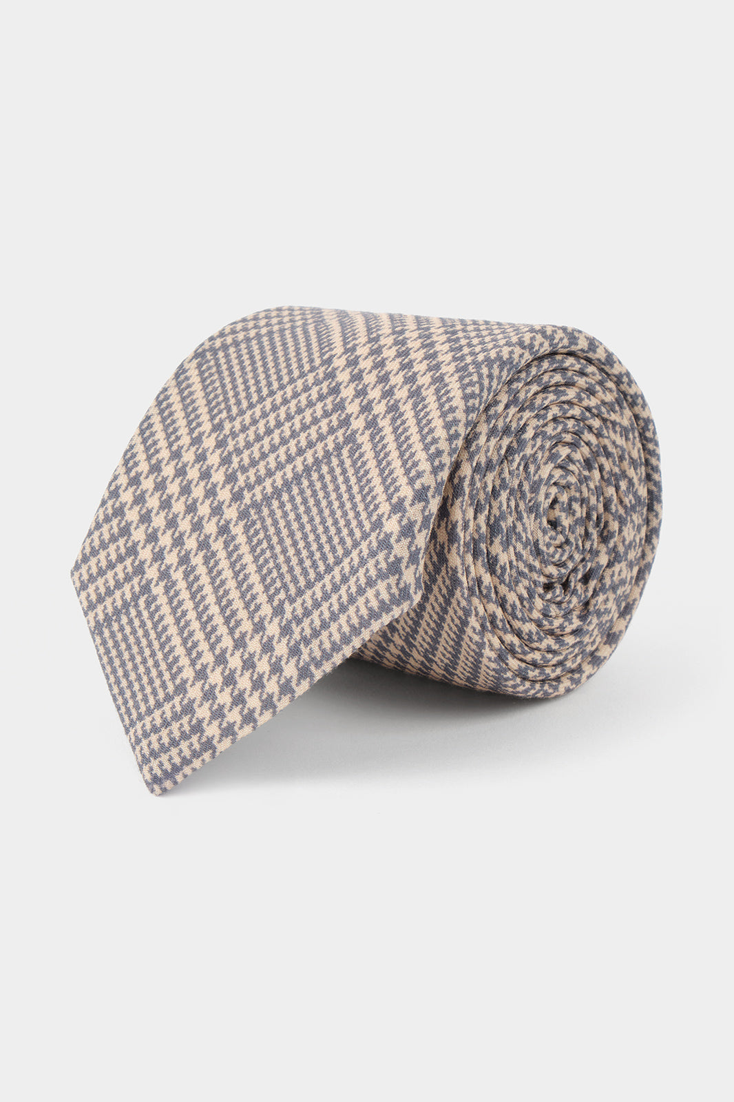 Vue sur fond blanc d'une cravate pour homme en 100% soie made in Italie imprimé princes de galles gris et beige.