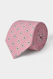 Vue sur fond blanc d'une cravate en tissu mélangé en rose à motifs fleurs blanches et marrons