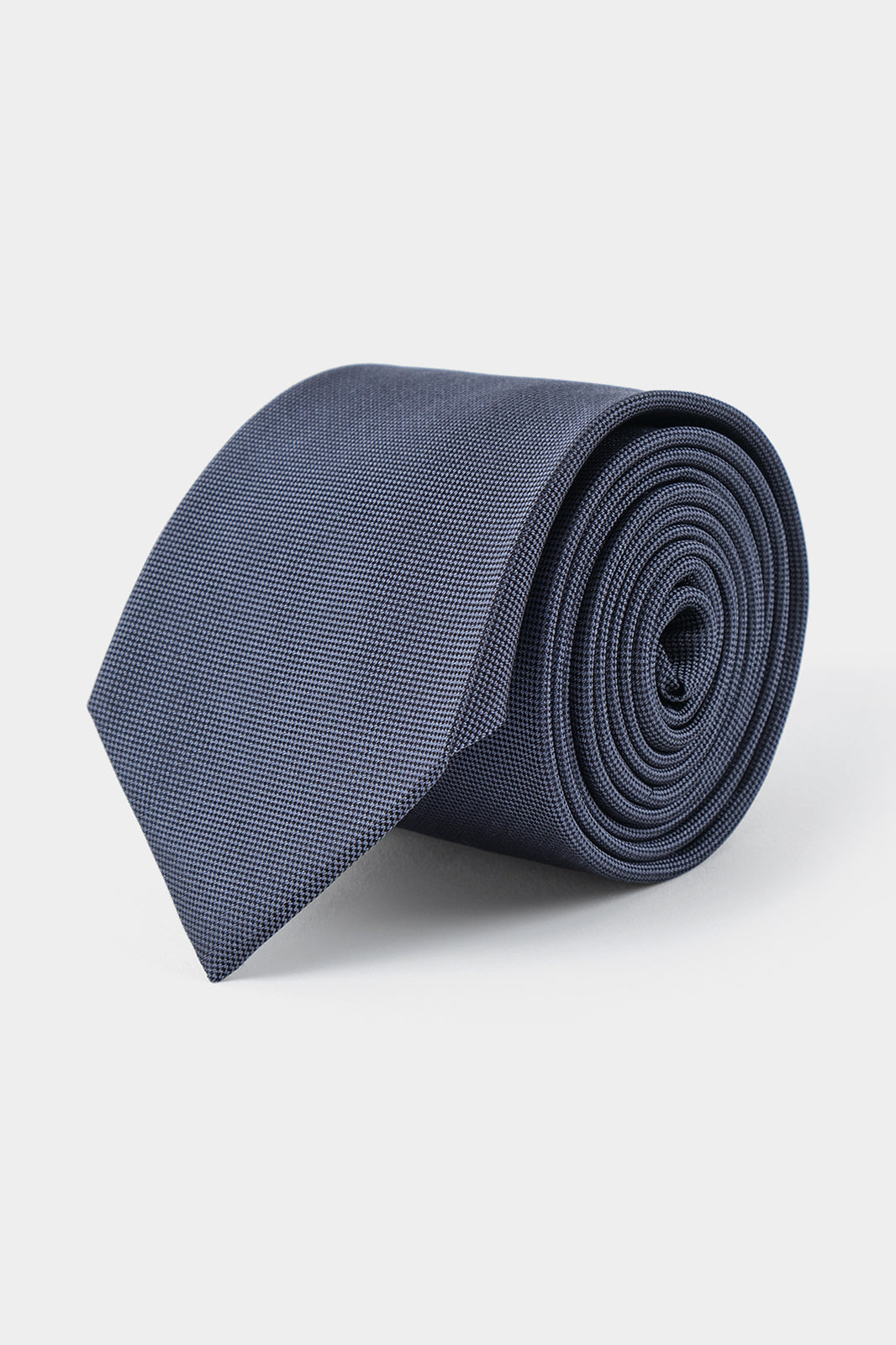 Vue sur fond blanc d'une cravate grise en 100 % soie