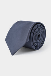 Vue sur fond blanc d'une cravate grise en 100 % soie