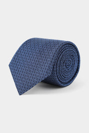 Vue sur fond blanc d'une cravate en 100% soie à motif en cercle bleu.