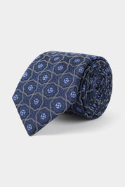 Vue sur fond blanc d'une cravate en 100% soie en bleu à motifs fleurs