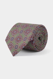 Vue sur fond blanc d'une cravate en soie verte à motifs fleurs