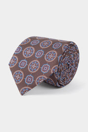 Vue sur fond blanc d'une cravate 100% soie en marron à motifs fleurs 