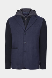 Vue sur fond blanc de la veste bi matière à capuche couleur gris marine fermeture à zip ainsi qu'à bouton, et 2 poches plaqués ainsi qu'une plus petite.