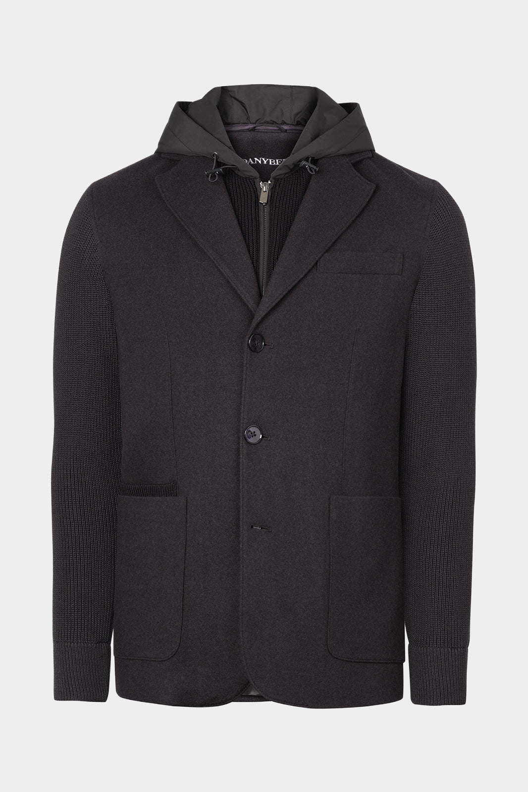 Vue sur fond blanc de la veste bi matière à capuche couleur gris foncé. La veste possède une fermeture à zip ainsi qu'à bouton, et 2 poches plaqués ainsi qu'une plus petite.