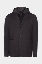 Vue sur fond blanc de la veste bi matière à capuche couleur gris foncé. La veste possède une fermeture à zip ainsi qu'à bouton, et 2 poches plaqués ainsi qu'une plus petite.