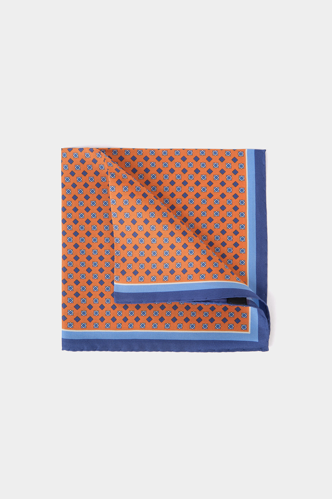 Vue sur fond blanc d'une Pochette en 100% soie à fond orange et à motif géométrique bleu et blanc