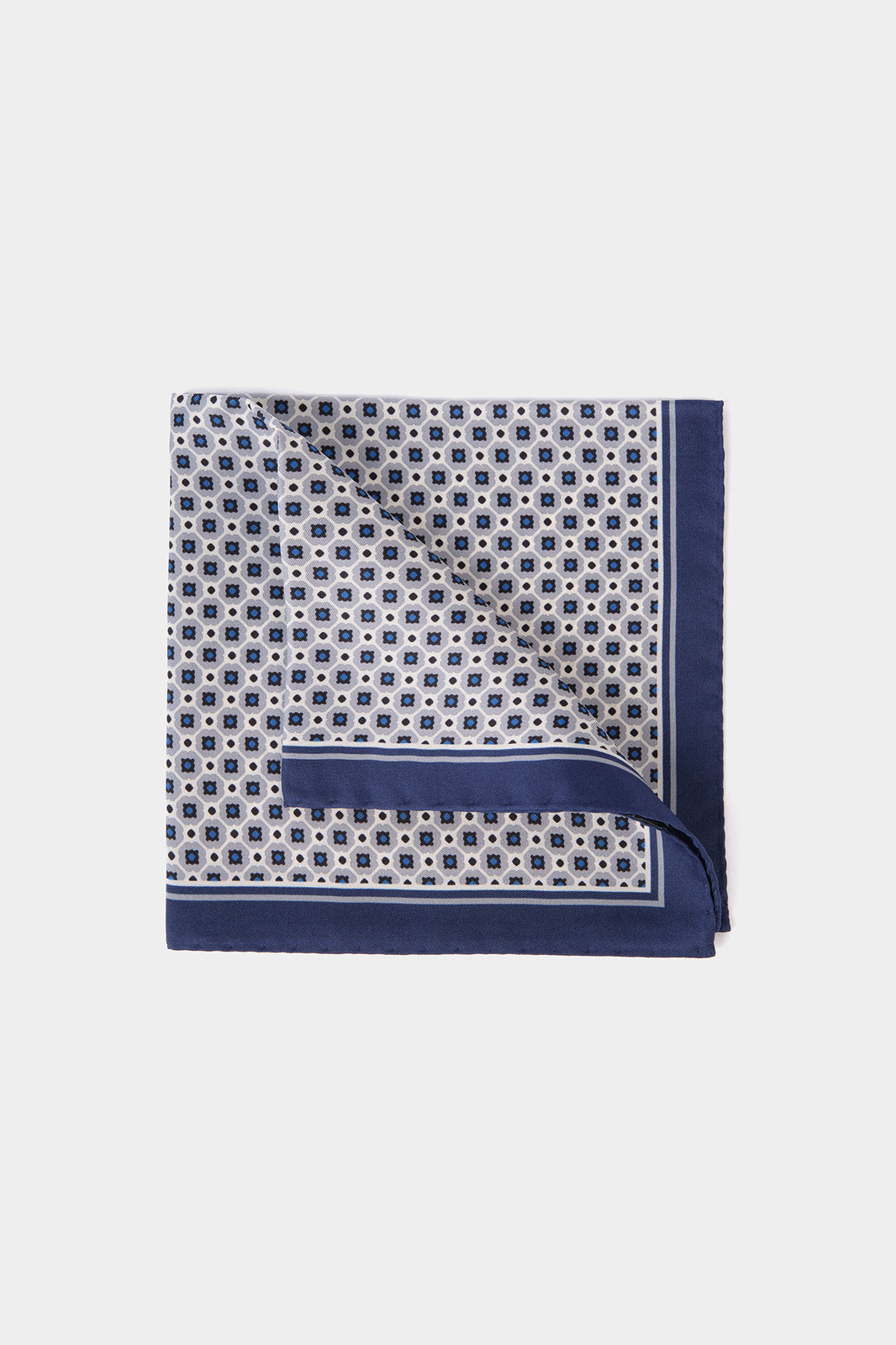 Vue sur fond blanc d'une Pochette en 100% soie à fond gris clair à motif géométrique bleu et blanc