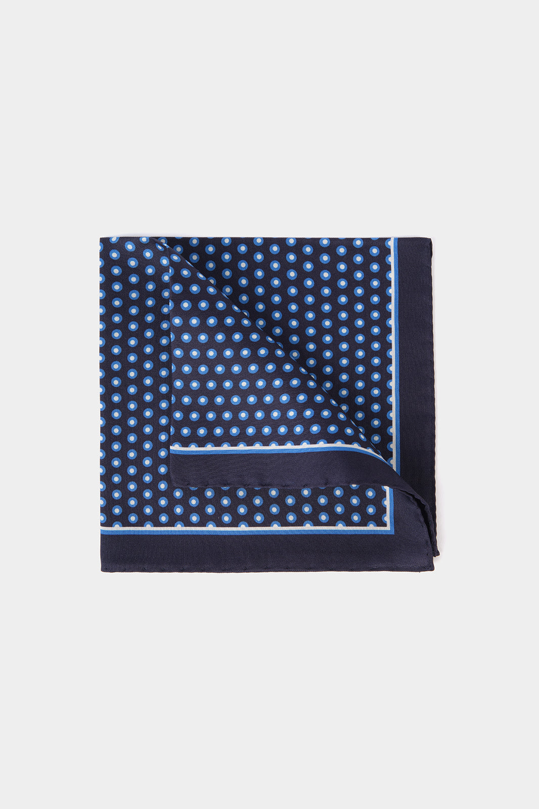 Vue sur fond blanc d'une Pochette en 100% soie fond bleu foncé à motif cercles bleu clair et blanc