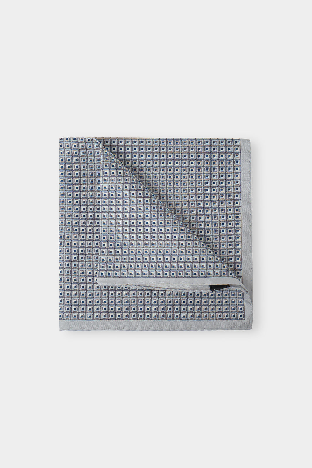 Vue sur fond d'une pochette grise à imprimés en 100% soie fabriqué en Italie.