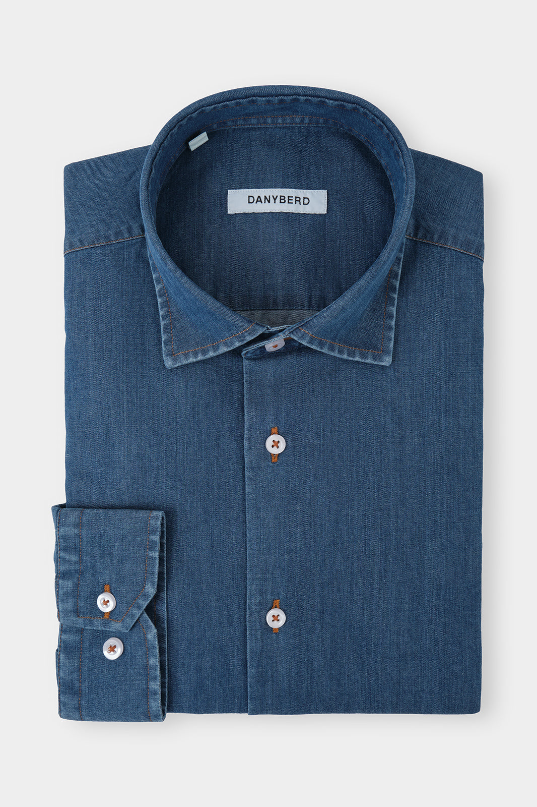 Vue sur fond blanc d'une chemise col français - Jeans coutures contrastées, sur une coupe cintrée avec boutons apparents ainsi que les 
poignets boutonnés et ajustables.