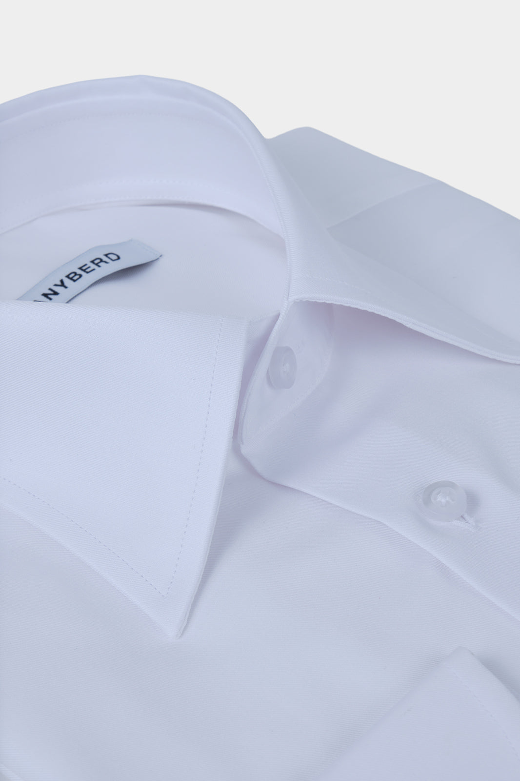 Vue sur fond blanc d'une chemise grand col en pointe blanche sur un 100% coton d'Italie.