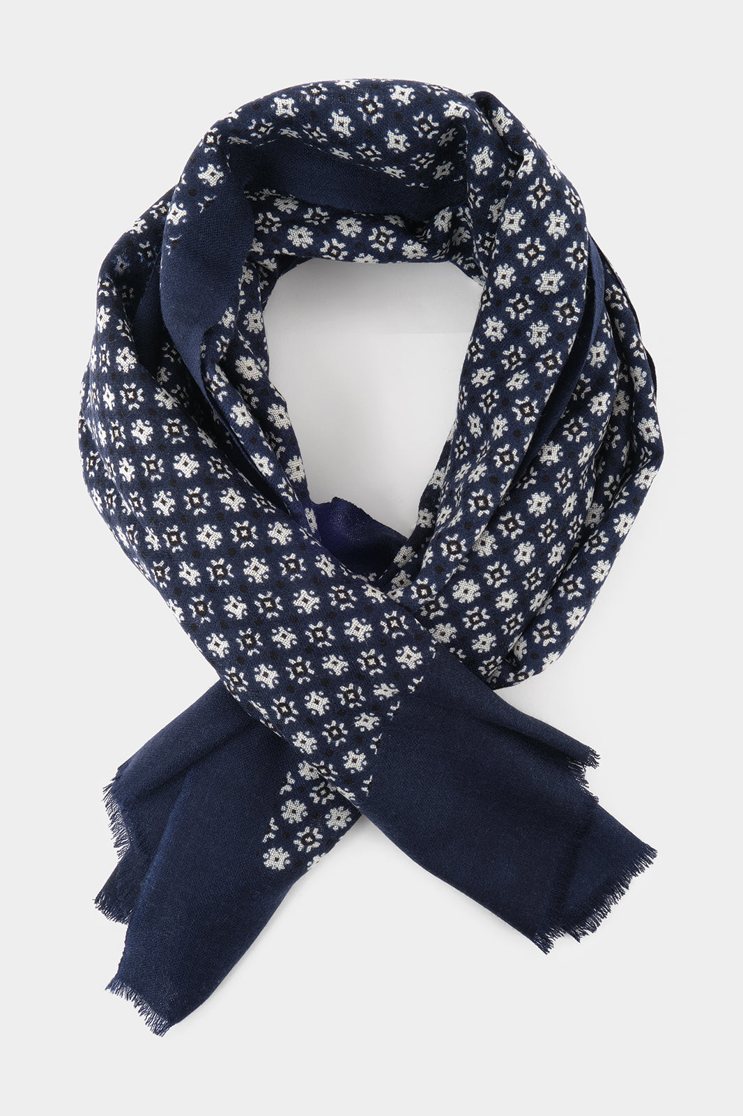 Vue sur fond blanc d'un chèche marine en laine avec des imprimés floraux