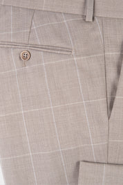 Zoom sur la matière et la poche arrière du pantalon de costume beige à carreaux. 