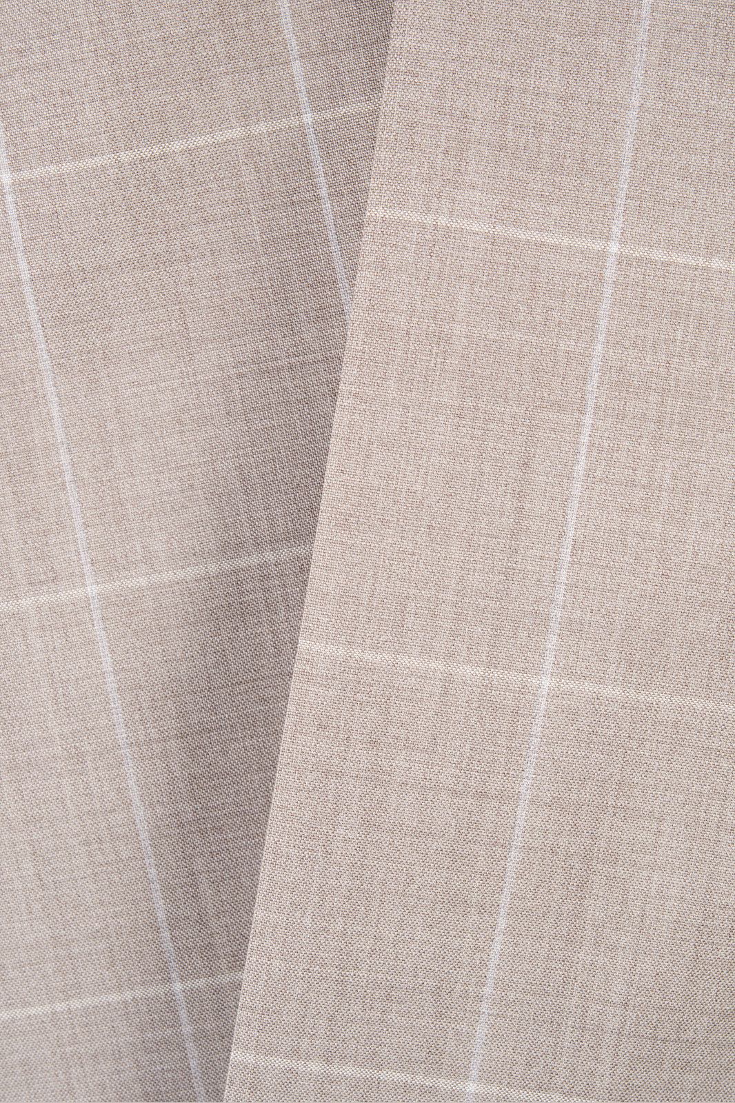 Zoom sur la matière du costume beige à carreaux. 