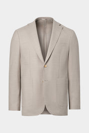 Vue sur fond blanc d'un blazer en laine stretch couleur beige. Avec une veste 2 boutons, 2 grandes poches plaquées, ainsi que boutonnière ouverte.
Tissus italiens en 98.4% laine et 1.6% élasthanne.
