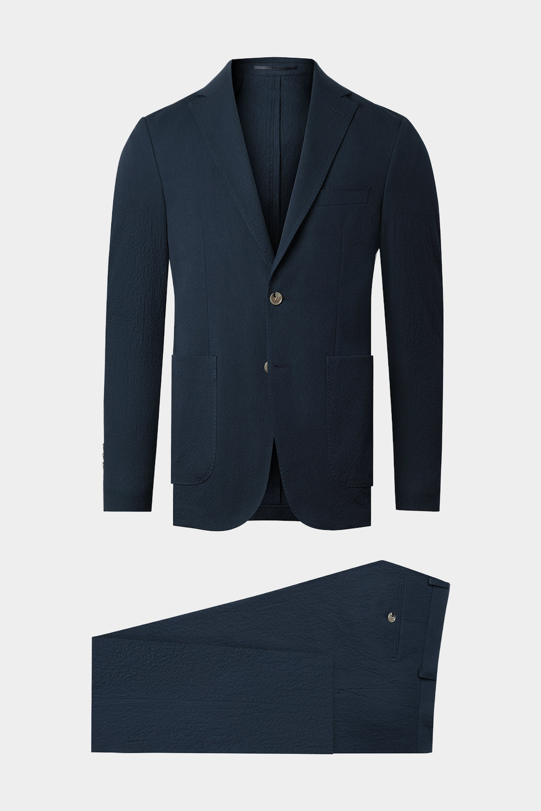 Vue surn fond blanc d'un costume en seersucker marine avec le boutonnage corne en coupe napolitaine.